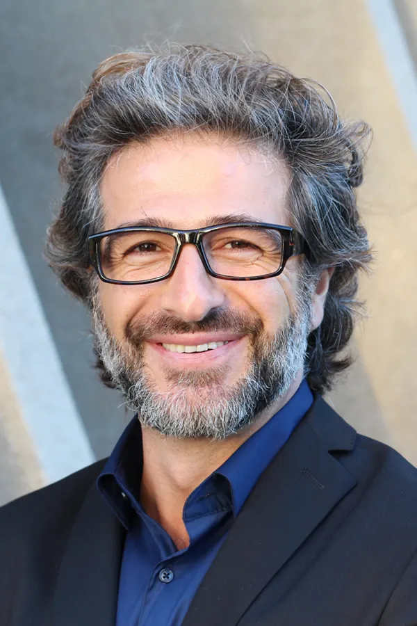A man with glasses, salt and pepper hair and a beard smiling because he received treatment for andropause and low testosterone from Carolyn Zaumeyer, MSN, APRN at LowTE Florida® in Greater Fort Lauderdale.