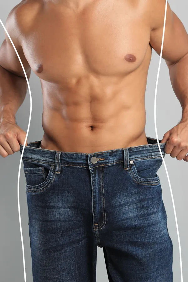 A man holds the waist of his jeans out to show weight loss. Get Contrave appetite suppressant treatment from Carolyn Zaumeyer, MSN, APRN at LowTE Florida® in Greater Fort Lauderdale.