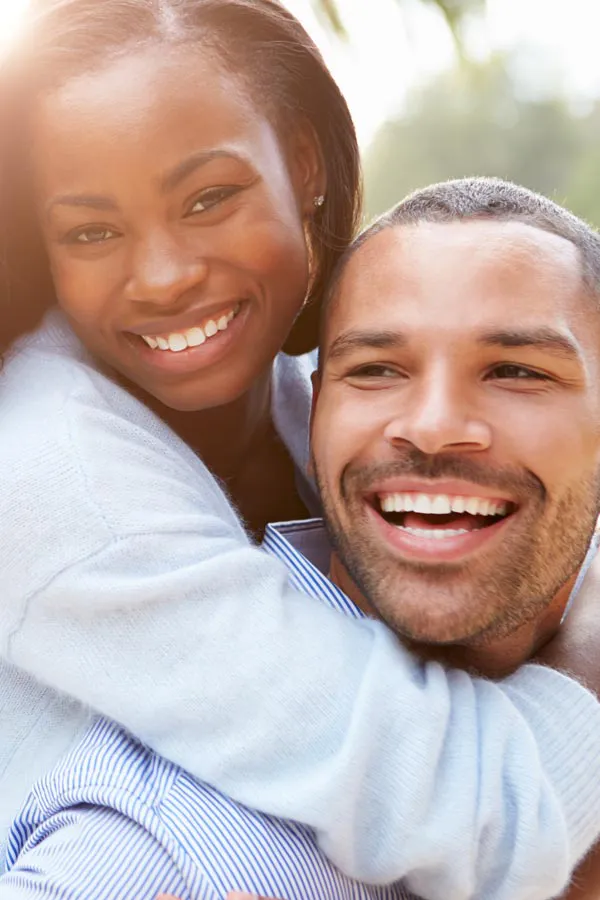 A woman riding on a man's back, both smiling due to help with erectile dysfunction from Carolyn Zaumeyer, MSN, APRN at LowTE Florida® in Greater Fort Lauderdale.
